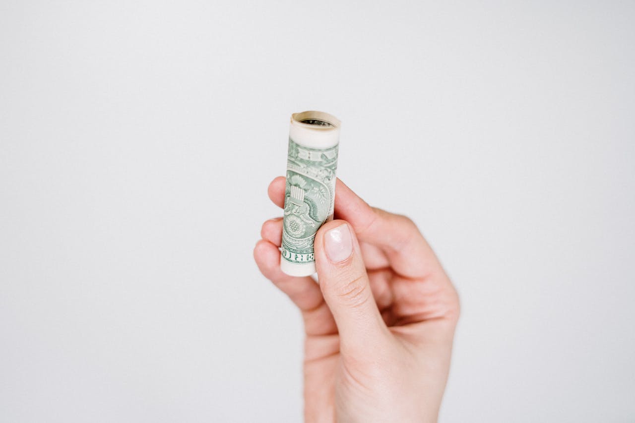 person-holding-rolled-up-bill